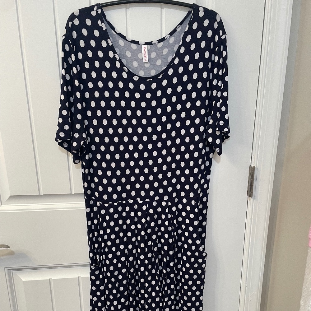 Navy blue with white polka dots. Pockets, elbow length sleeves.